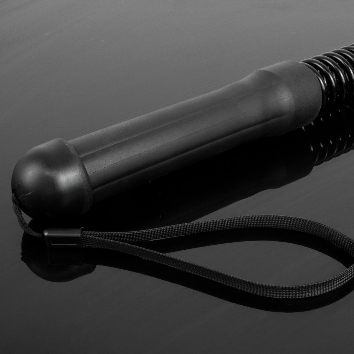 A close-up studio shot of a battle rope bar with a silicon handle, photographed on a dark reflective surface.