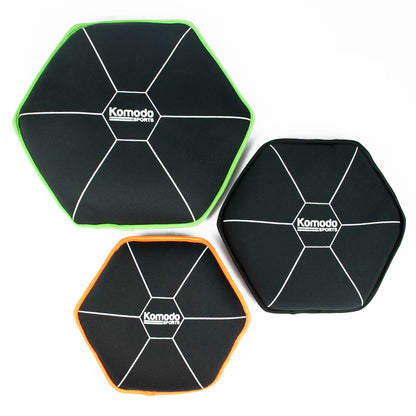 Three black hexagonal sandbags with green and orange borders on a white background, featuring the Komodo brand.