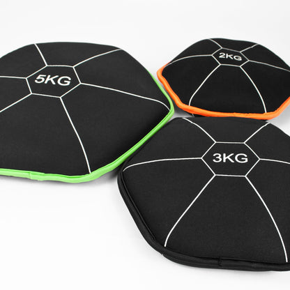 Three black hexagonal weight bags for gym storage, labeled 5KG, 3KG, and 2KG, arranged on a white background. The bags have white lines and are accented with bright green, orange, and white trim.