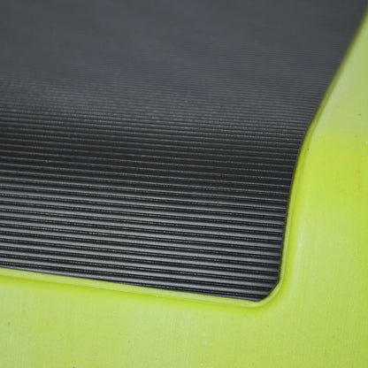 Close-up of a black ribbed textured mat or pad attached to a bright neon yellow-green frame or base.