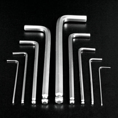 Nine silver metal hex wrenches in different sizes arranged in a symmetrical pattern on a black reflective background.