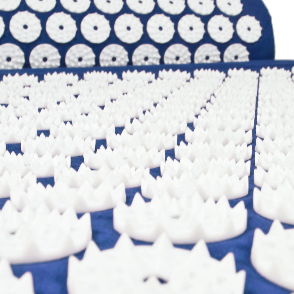 White massage foam roller tips arranged in rows on a dark blue surface, with a matching blue acupressure mat showing circular textured rollers.