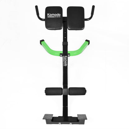 Komodo Sports back extension bench with a black metal frame, bright green curved handles, and black padded seat, backrest, and footrest on a white background.