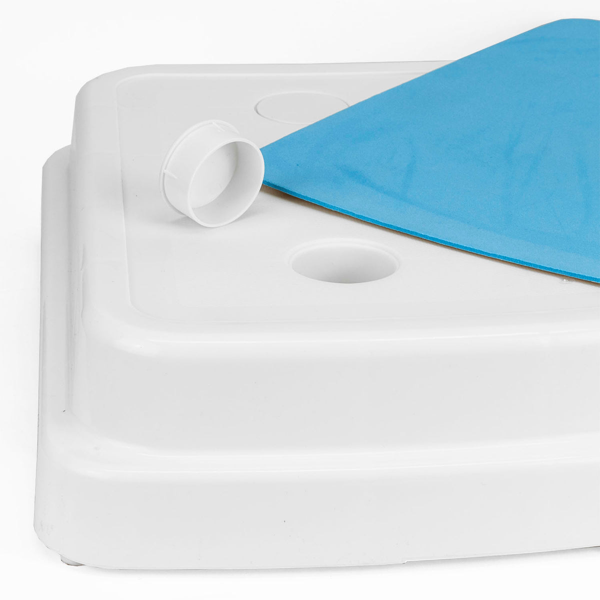 Close-up of a white plastic bath step edge with a circular opening and a blue non-slip mat partially visible on top, photographed against a white background.