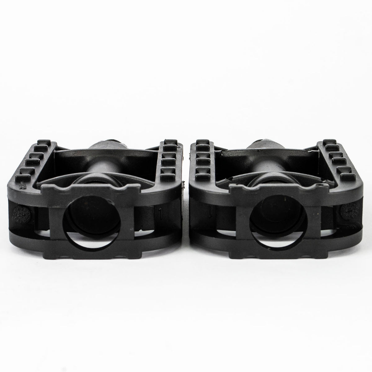 A pair of black plastic motorcycle or dirt bike foot pegs shown from the side against a plain white background.