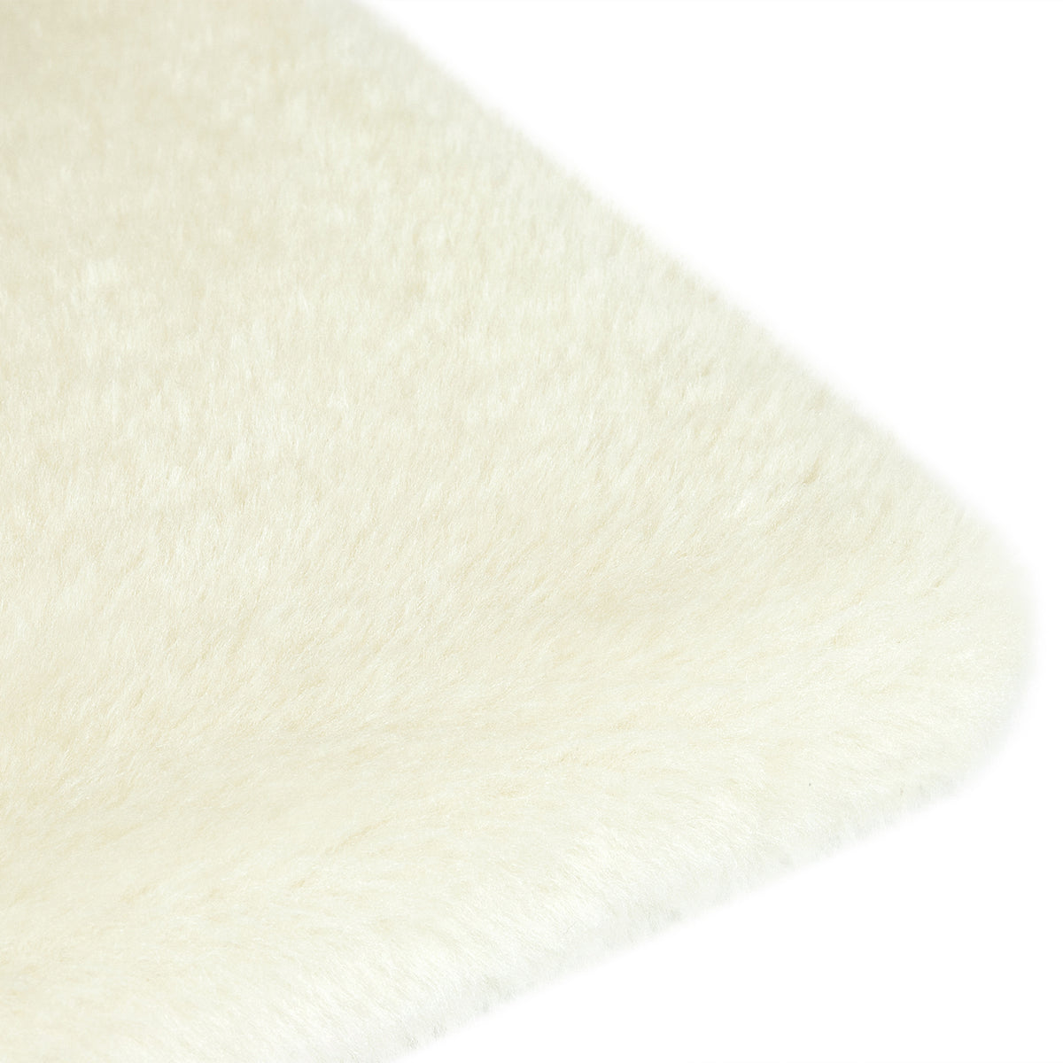 A close-up of a soft, fluffy faux fur material in a warm off-white/cream colour, showing the texture and corner detail against a plain white background.