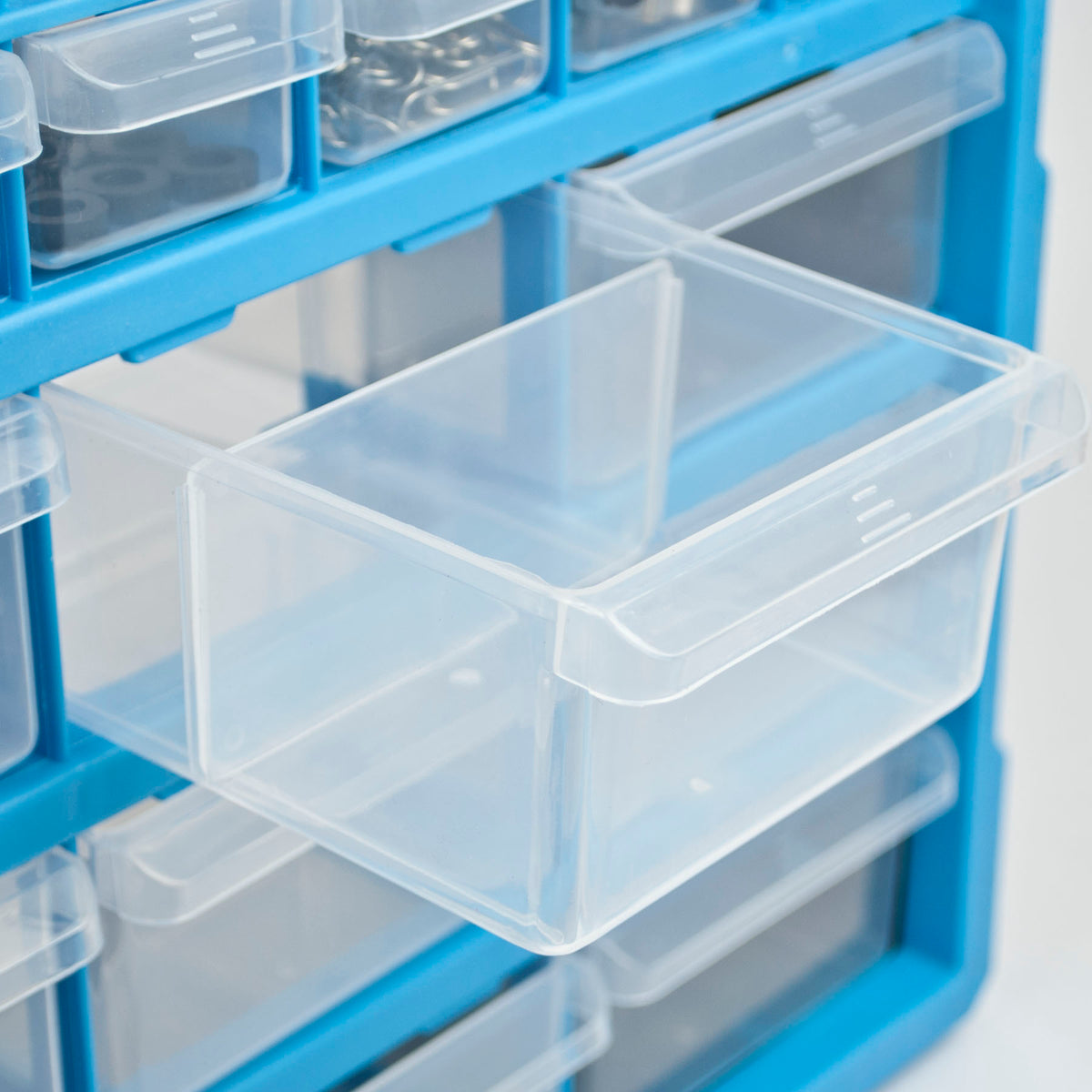Clear plastic drawer organizer bins shown in a blue storage rack, with one drawer pulled open.