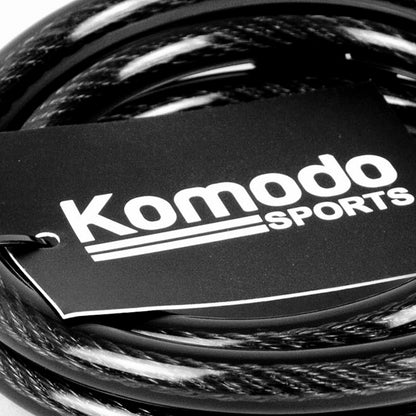 A close-up of a coiled black cable with a black paper tag printed with the white text 'Komodo Sports'.