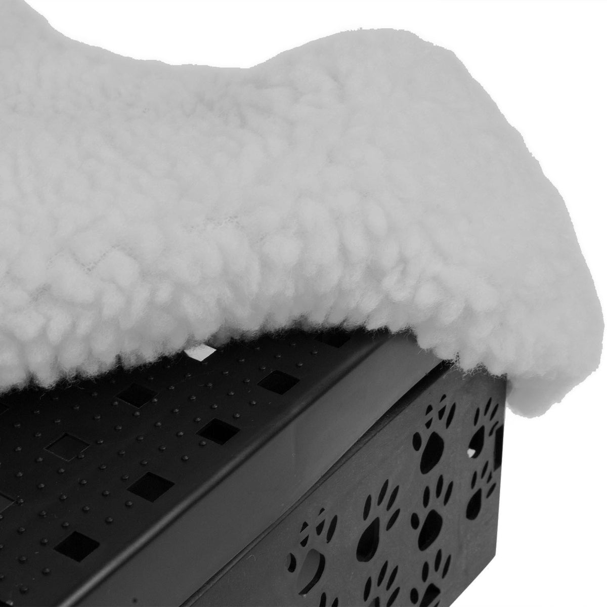 A close-up of a white sherpa fleece draped over a black plastic pet step with paw-print cutouts, shown against a plain white background.