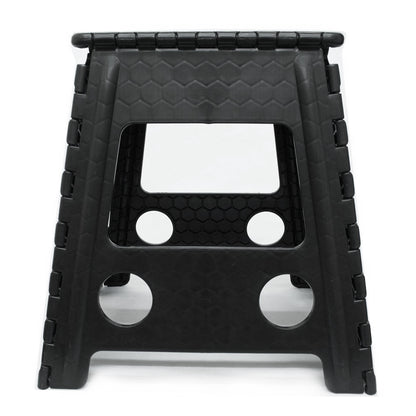 A black foldable plastic step stool with a textured honeycomb pattern on the top surface and side panels, featuring circular cutouts on the lower legs, shown on a white background.