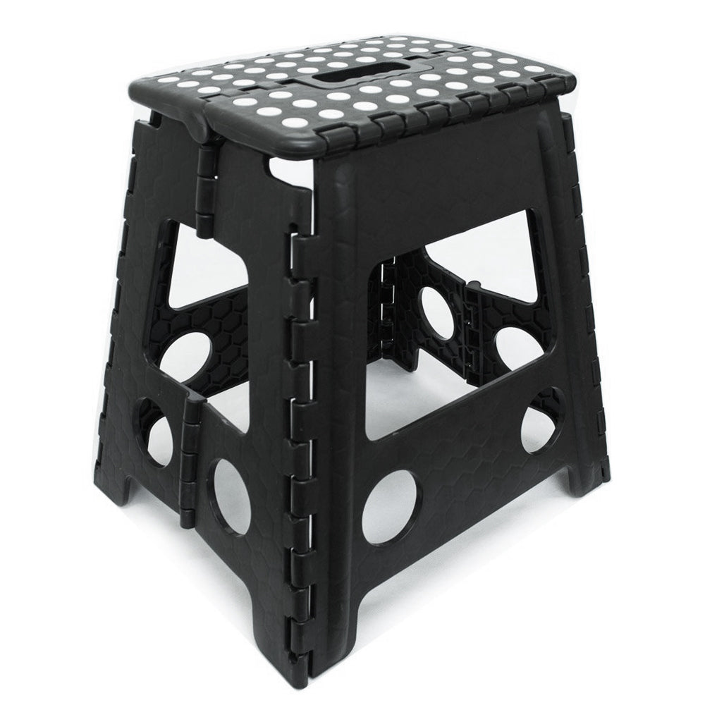 A black foldable plastic step stool with a textured, dotted non-slip top and circular cutouts on the sides, shown on a white background.