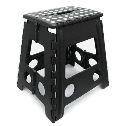 A black foldable plastic step stool with a textured, dotted non-slip top and circular cutouts on the sides, shown on a white background.