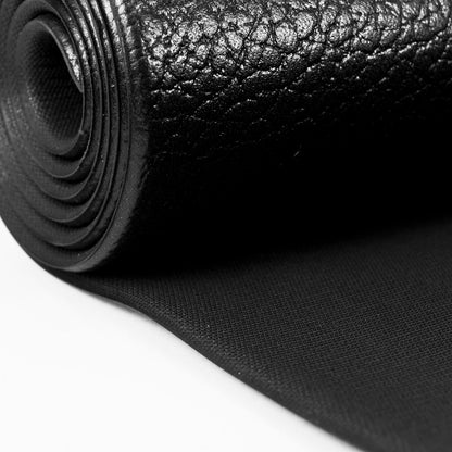 A close-up of a rolled black textured material,  rubber, with a pebbled surface and a flat woven backing, shown on a white background.