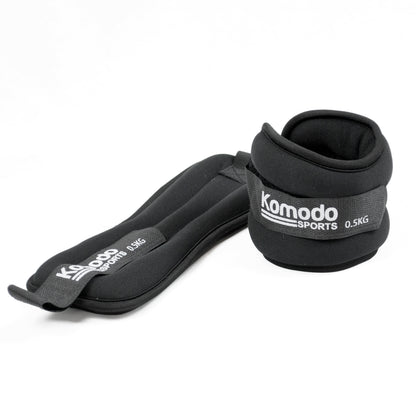 A pair of black Komodo Sports adjustable wrist wraps, each labelled 0.5kg