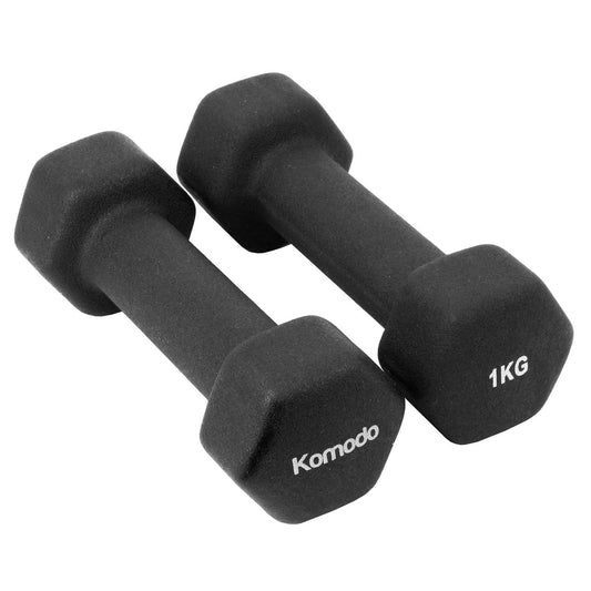 Two black neoprene hexagonal dumbbells on a plain white background, with the left dumbbell showing the brand name 'Komodo' and the right dumbbell showing '1KG' in white text.