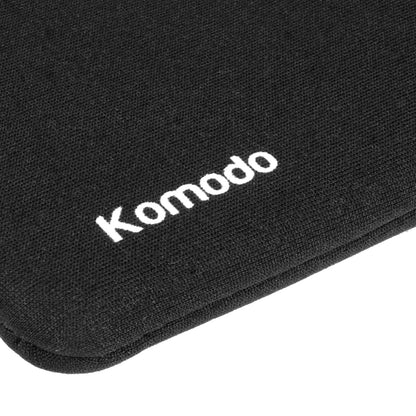 Close-up of a black textured fabric surface with the word 'Komodo' printed in white near the center, on a white background.