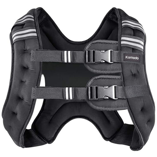 A black padded weighted vest with adjustable straps and plastic buckles, featuring white stripe accents on the shoulder straps, photographed on a solid white background. The brand name 'Komodo' is visible on a small label on the right side.