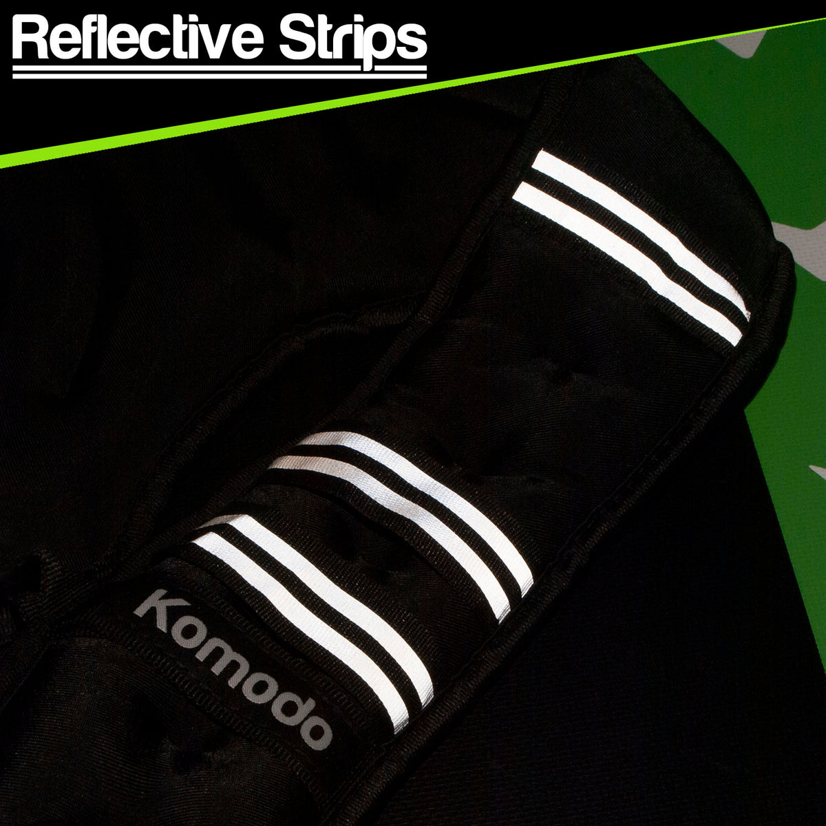 Close-up of a black reflective safety strip product labeled 'Reflective Strips' and 'Komodo', showing three white reflective stripes on a black fabric background.
