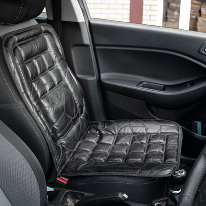 A black quilted car seat cushion pad installed on a front car seat inside a vehicle cabin.