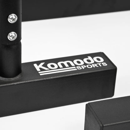 Close-up of a black gym accessory with the white printed brand name 'Komodo Sports' on a white studio background.
