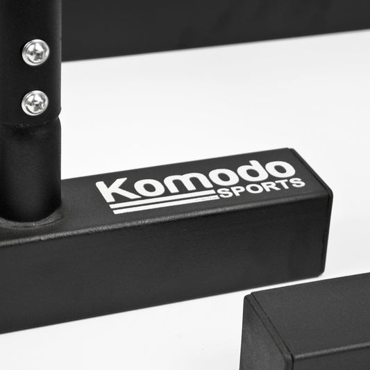Close-up of a black gym accessory with the white printed brand name 'Komodo Sports' on a white studio background.