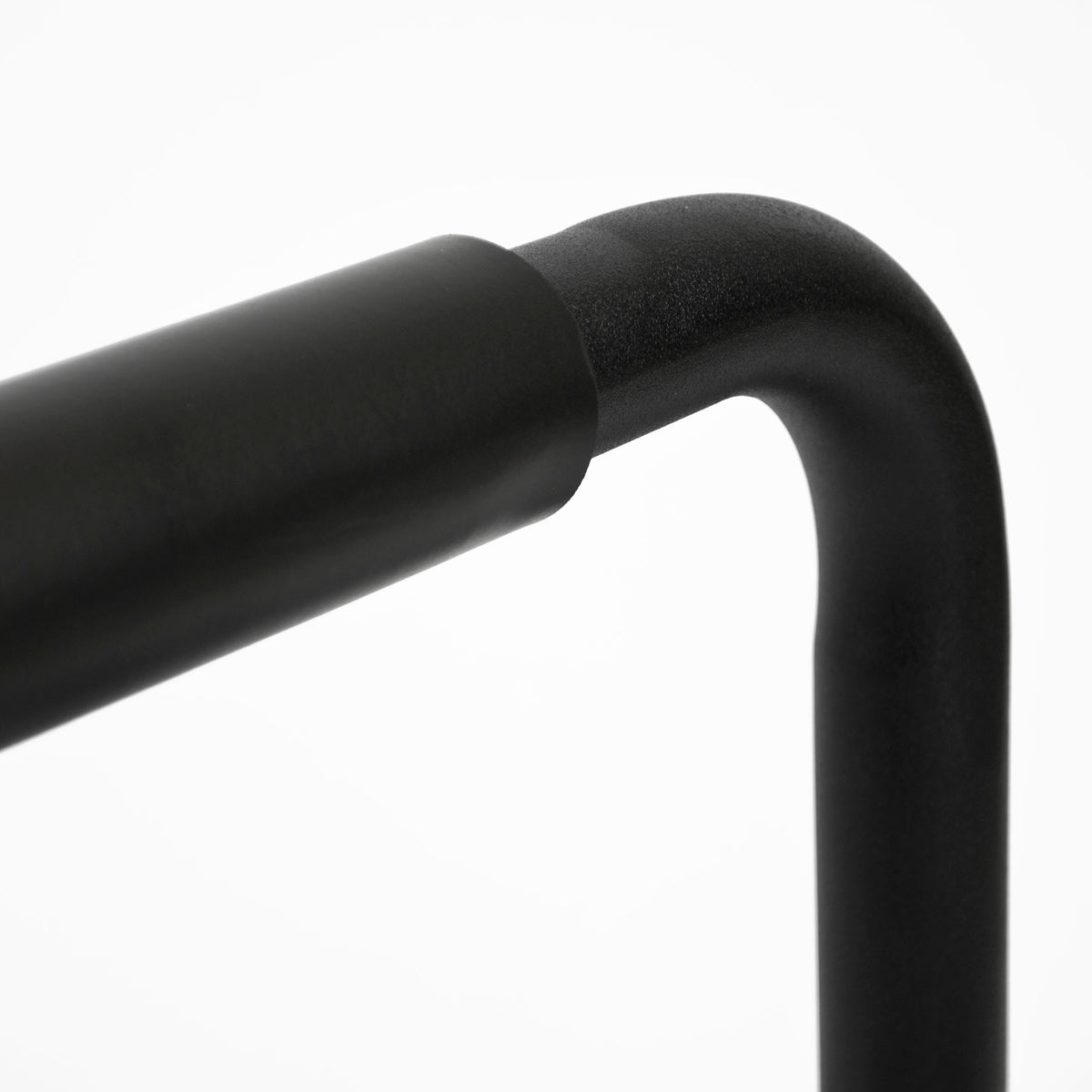 Close-up of a matte black metal frame corner with a curved arm and vertical post on a white background.