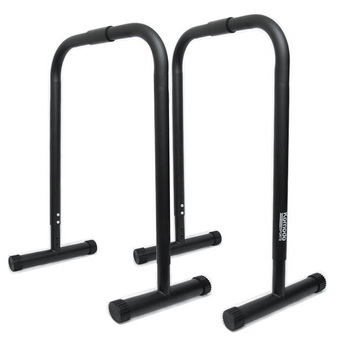 Two black metal push-up or parallel bar stands with T-shaped base plates, shown on a plain white background. A vertical white brand label reading 'Komodo' is visible on the right stand.