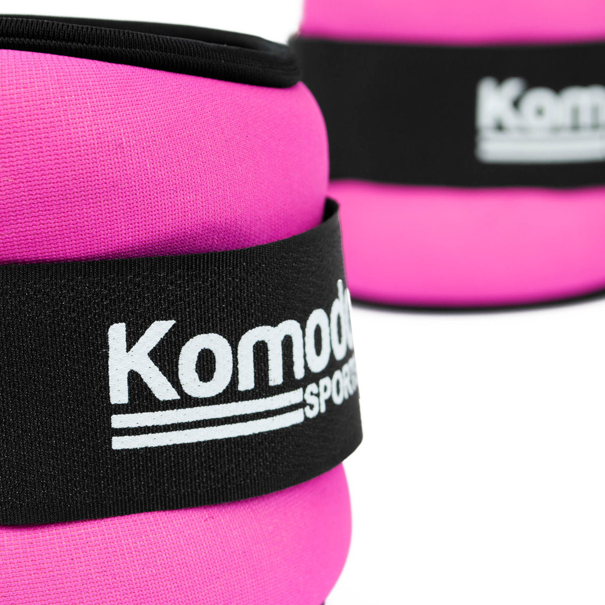 Pink ankle weights with black straps and 'Komodo Sports' branding on a white background