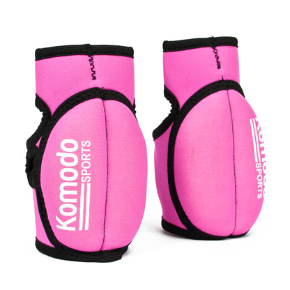 A pair of pink neoprene fingerless hand grip/weightlifting with black trim and white 'Komodo Sports' branding, displayed on a clean white background.