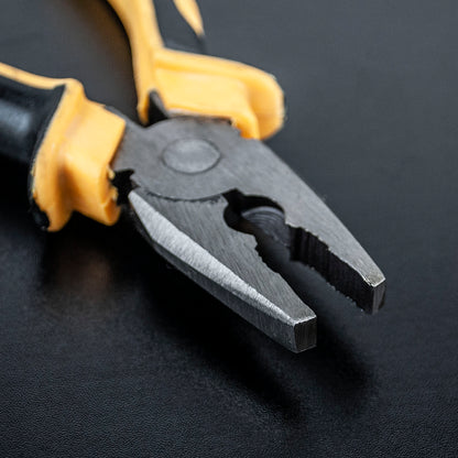 Pair of pliers with black and yellow handles on a dark background