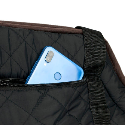 Close-up of a black quilted bag with a blue smartphone tucked into a front zipper pocket, showing the texture of the fabric and a brown trim edge against a white background.