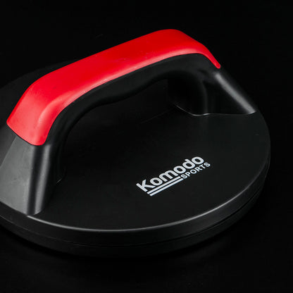 A black Komodo Sports push-up handle with a red handle, shown on a solid black background.