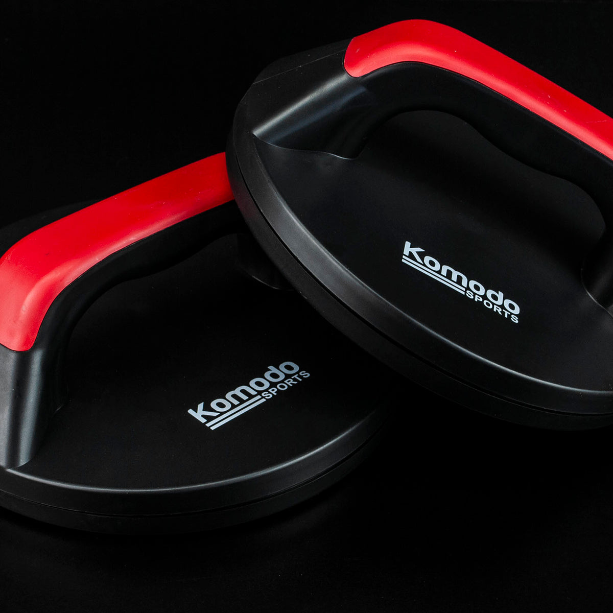 Two black Komodo Sports push-up boards with red bars, shown overlapping on a black background.
