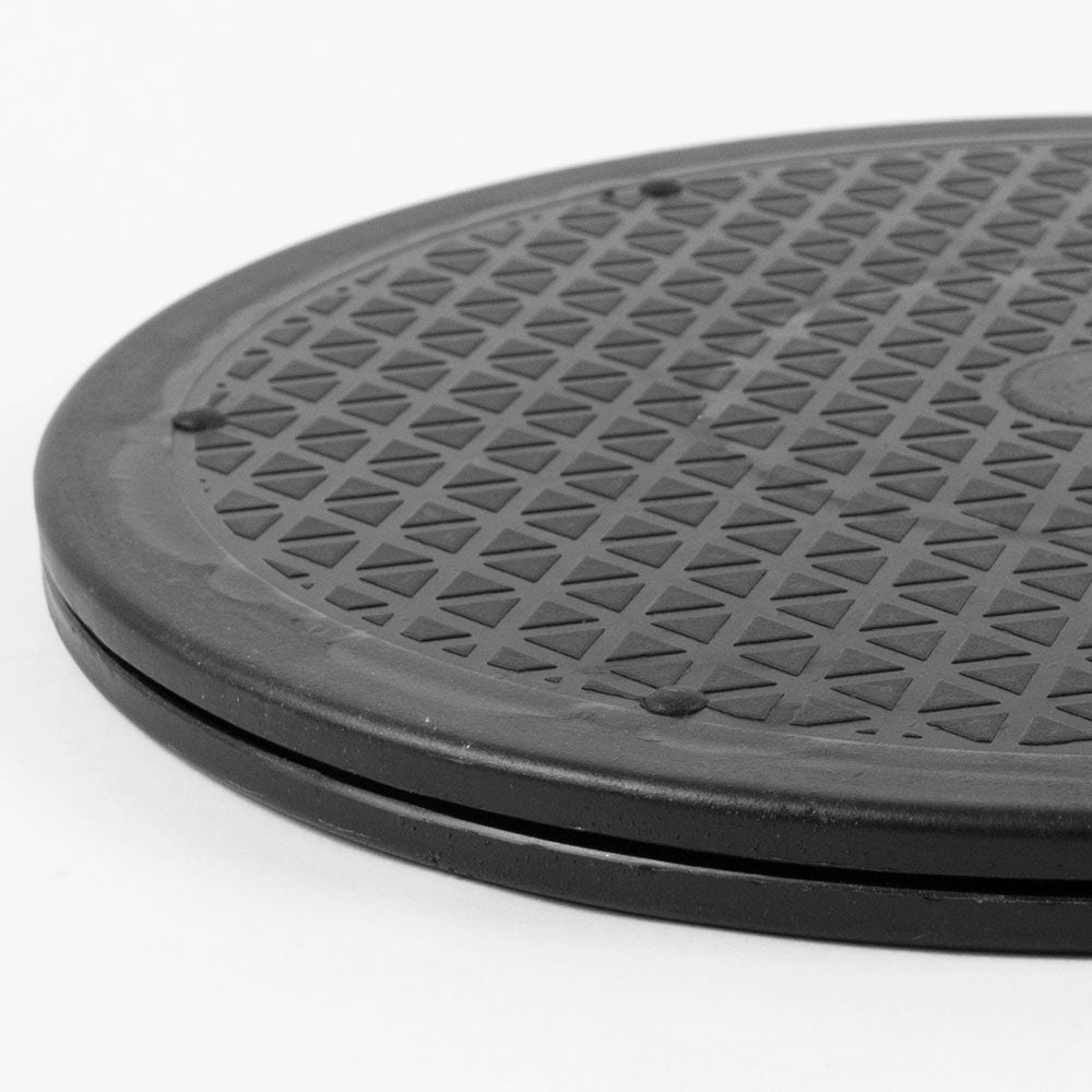 A close-up of a rotating platform with a raised border and a repeating triangular pattern, photographed on a plain white background.