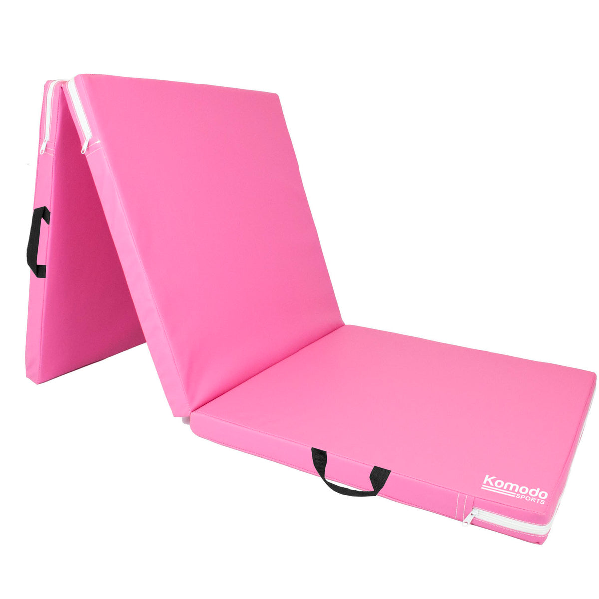 Pink portable folding gymnastics mat with black handles and a white Komodo brand logo, shown folded to display its thickness and portability on a white background.