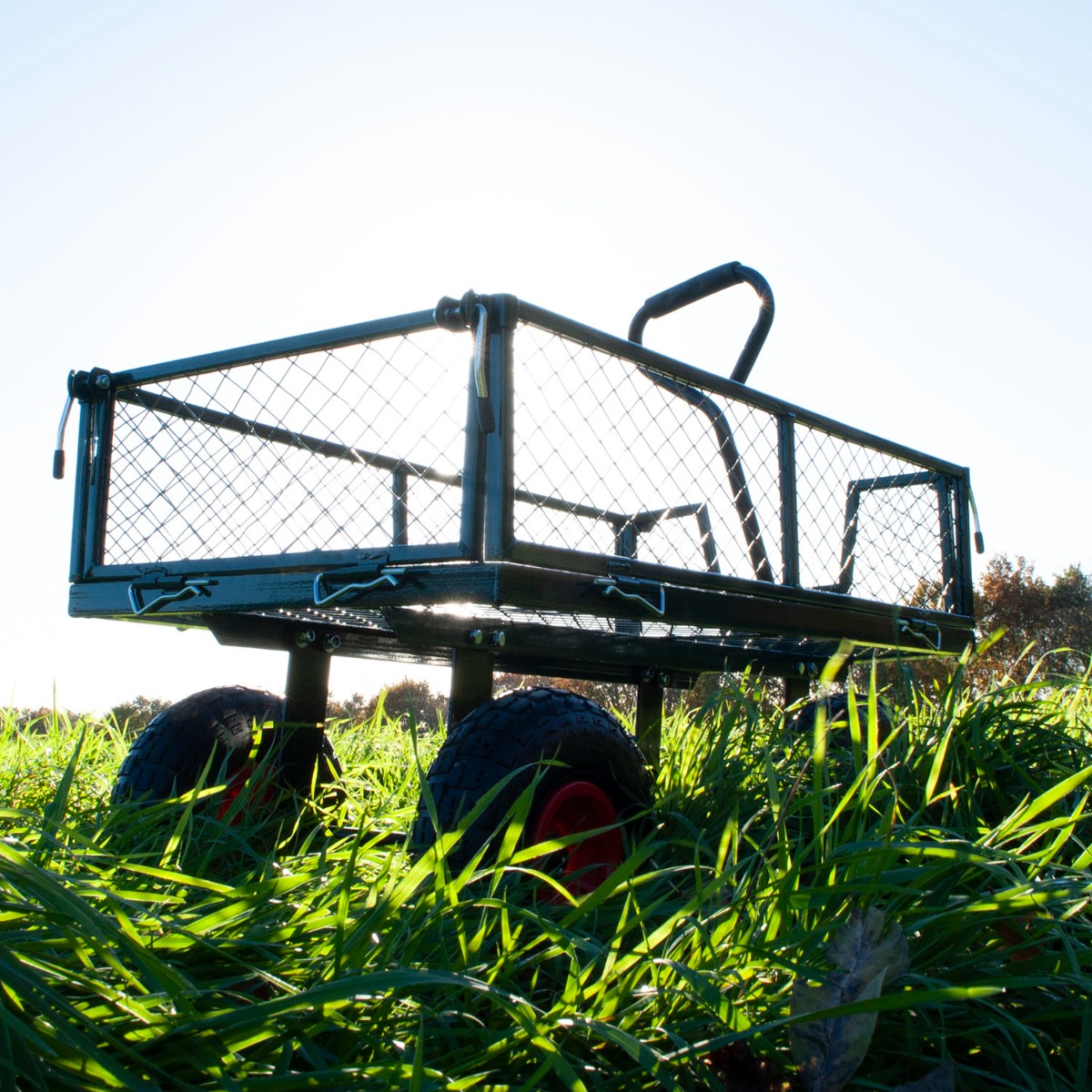 Large green heavy duty garden cart with steel frame and all-terrain wheels loaded with gardening supplies outdoors