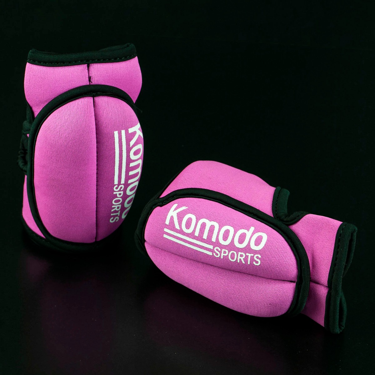 Pair of pink neoprene weighted gloves with Velcro straps, each weighing 0.5kg, designed for exercise and rehab use
