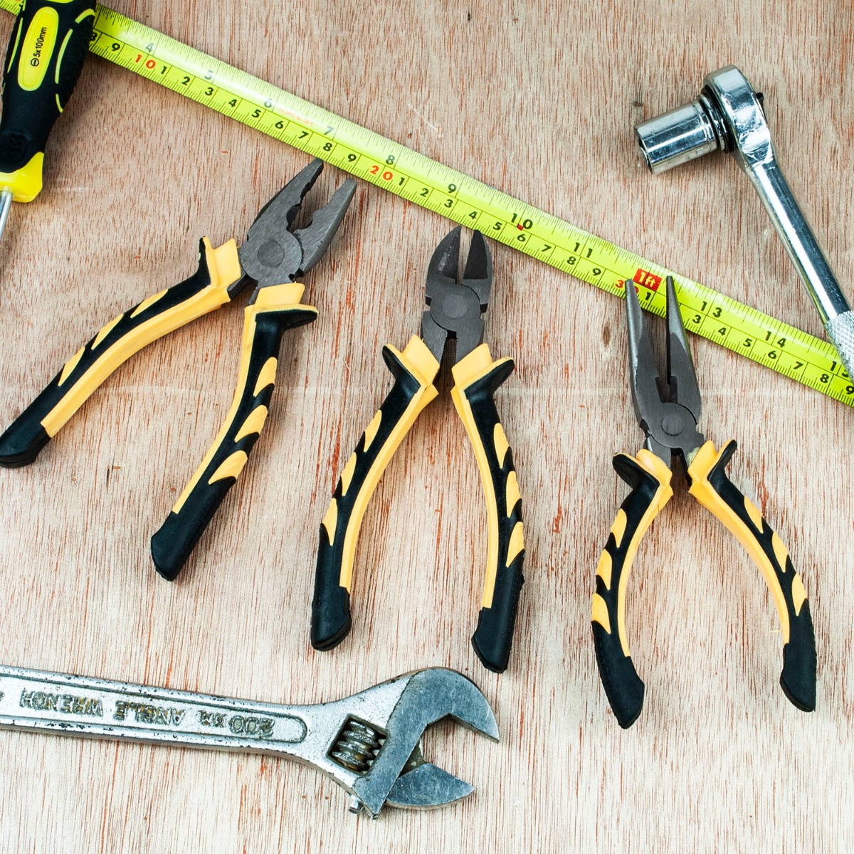 Set of three tempered carbon steel pliers with black and yellow soft grip handles including long nose, side cutter, and combination types