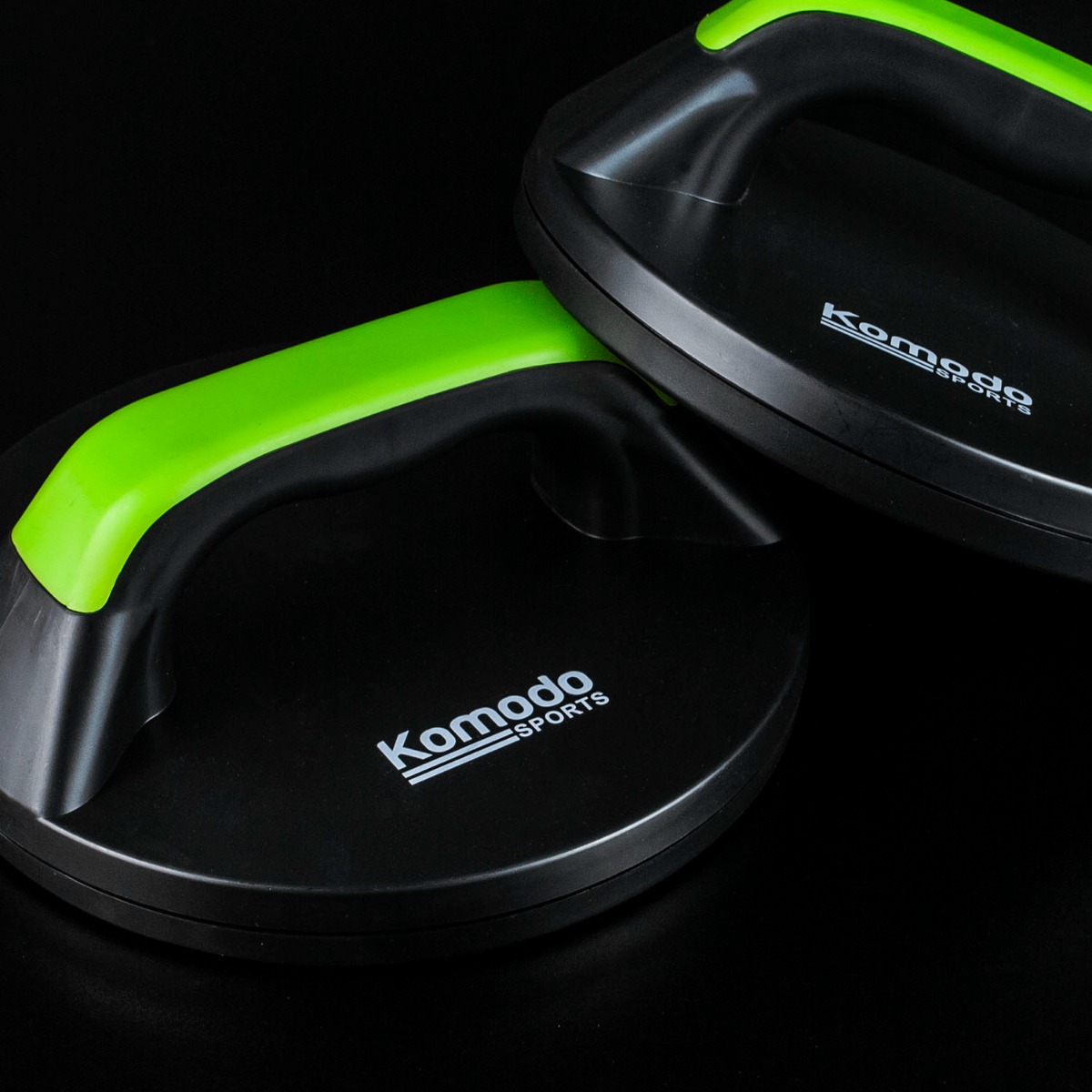 Green Komodo rotating exercise handles shown on a white background highlighting ergonomic grip and swivel base design