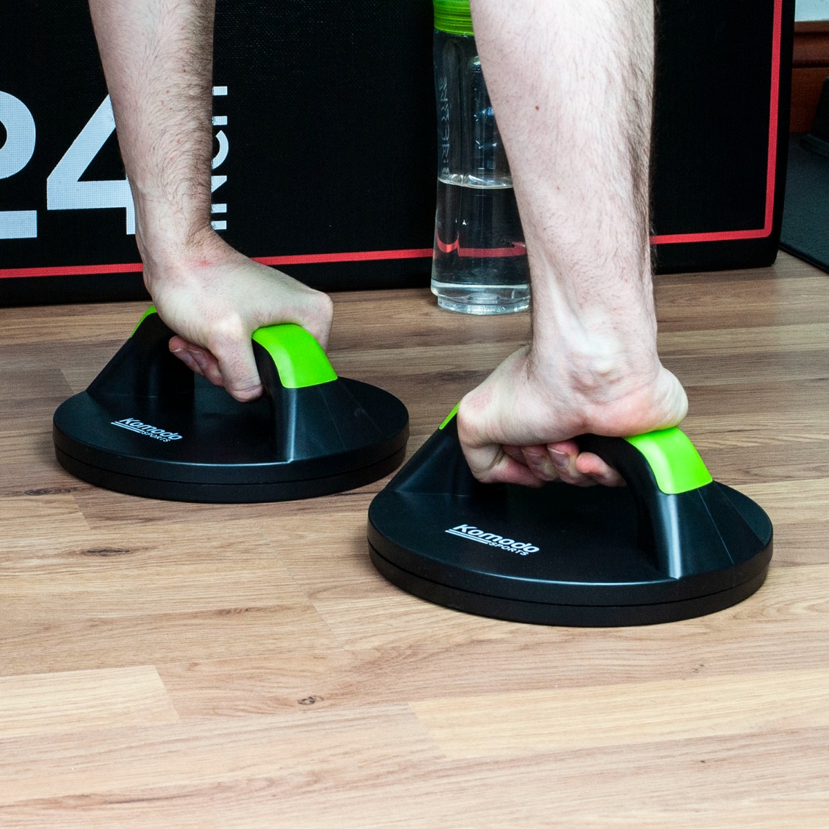 Green Komodo rotating fitness push up grips showing ergonomic handles designed to reduce wrist strain during workouts