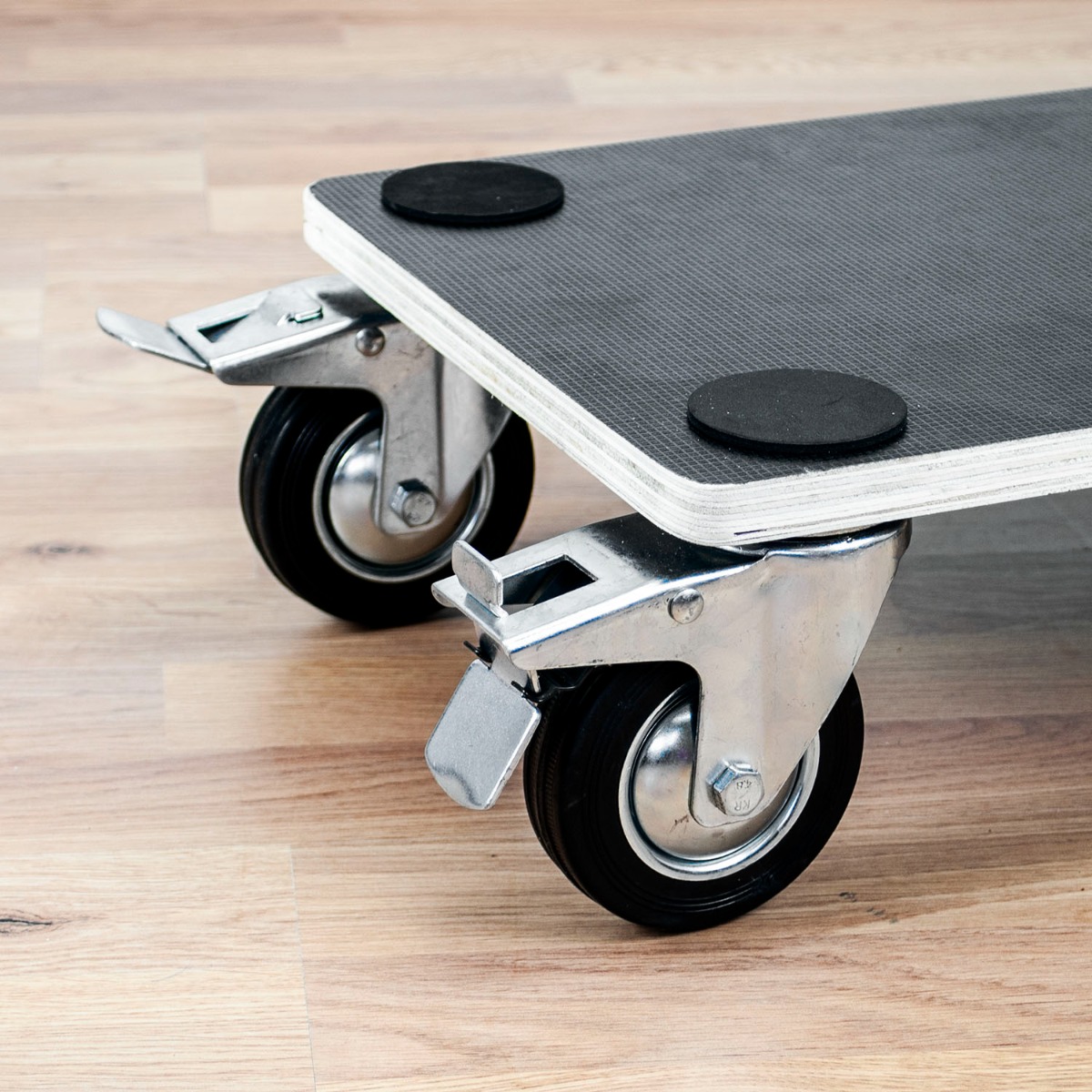 Wooden rolling furniture platform with four swivel wheels, brake locks on front wheels, and anti-slip surface with corner pads