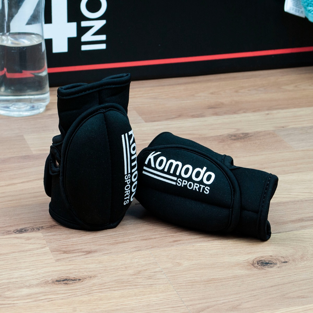 Pair of black Komodo weighted training gloves with neoprene padding and Velcro straps, each weighing 1kg