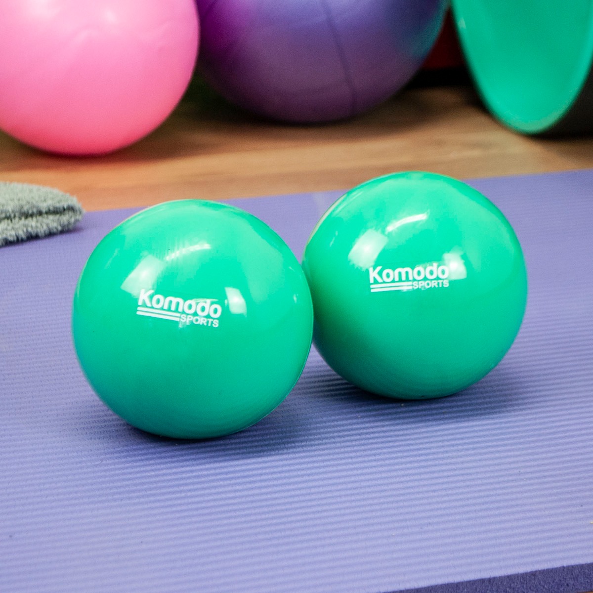 Pair of green hand held exercise balls weighing 1kg each made from PVC with sand filling for toning workouts