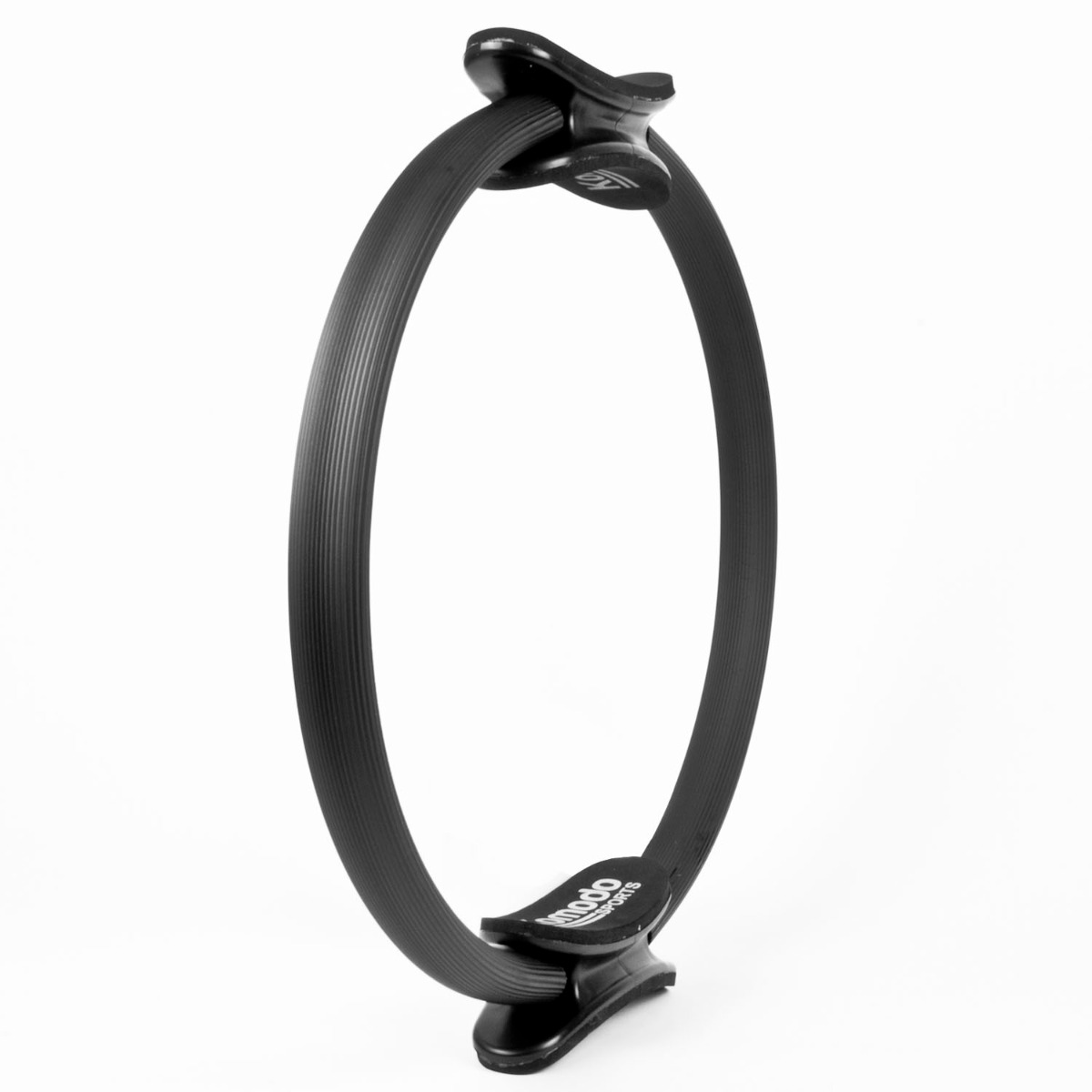 Black pilates ring 15 inch with foam padded handles resting on a white surface for fitness and stretching exercises